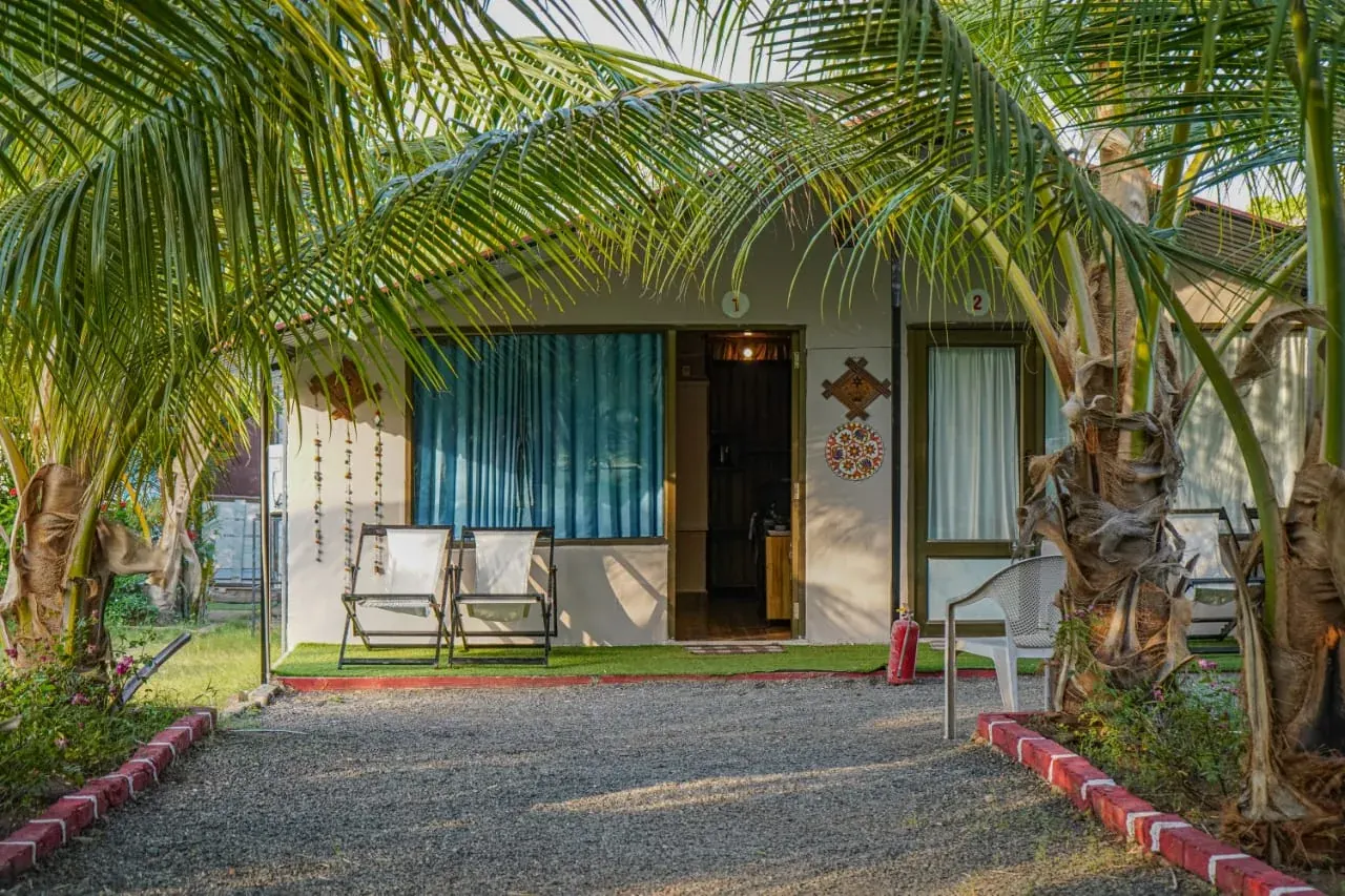 Cottage exterior and palm gardens at Unity Village Resort, Kevadia